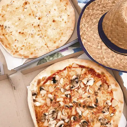 A person cutting a pizza with a pizza cutter